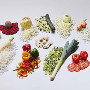 Vegetable slicing machine with interchangeable cutting heads