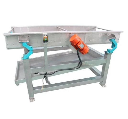 Vibrating dewatering machine removing surface water from washed vegetables